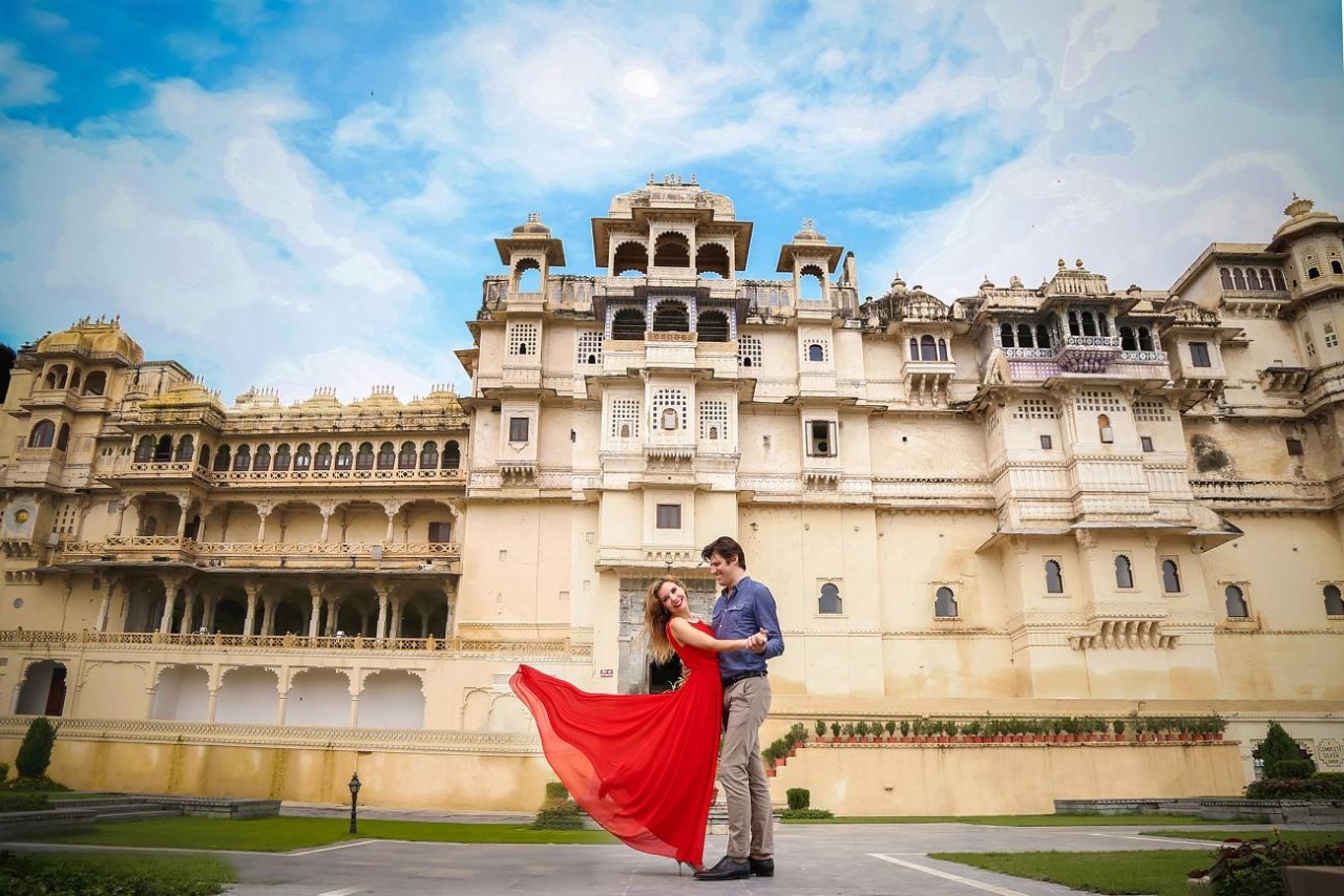 Bride and groom walking in front of Udaipur City Palace - royal destination wedding in Rajasthan