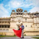Bride and groom walking in front of Udaipur City Palace - royal destination wedding in Rajasthan