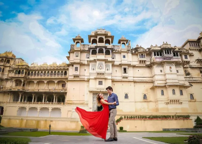 Bride and groom walking in front of Udaipur City Palace - royal destination wedding in Rajasthan